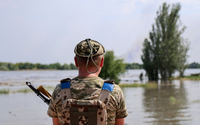 Ukraiński żołnierz na zalanej ulicy w Chersoniu