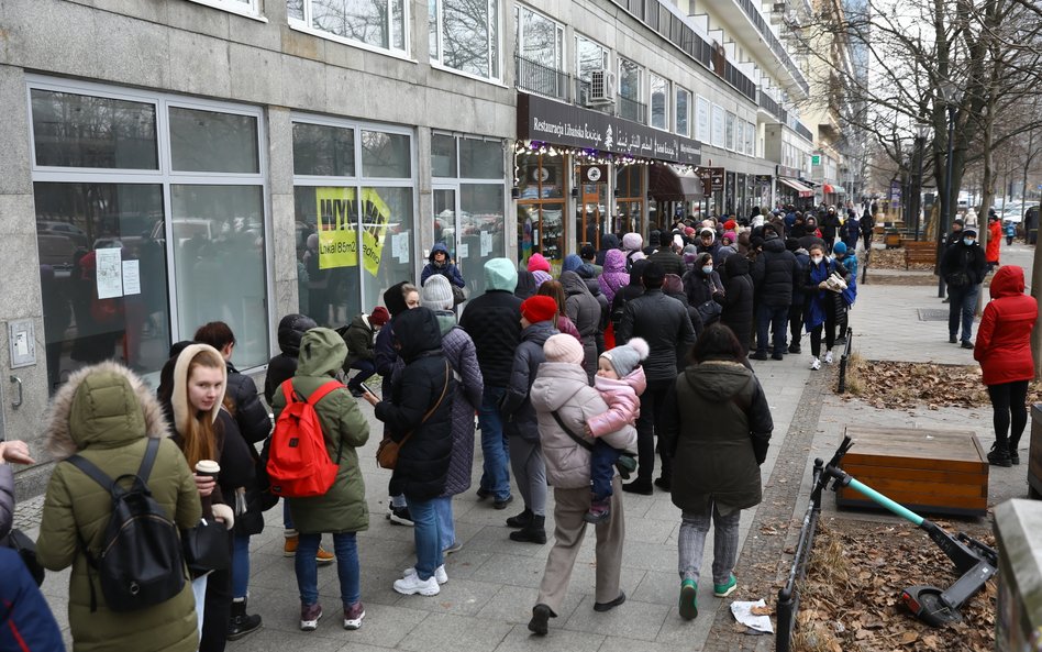 Uchodźcy z Ukrainy stoją w kolejce do jednego z warszawskich kantorów