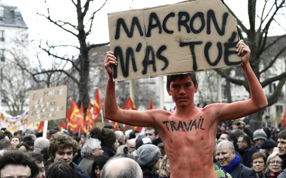 Jeden z uczestników czwartkowego protestu z kartonem z napisem "Marcon mnie zabił" i słowem "praca" 