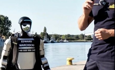 Humanoidalny robot Edward Warchocki na tle polskich okrętów w Świnoujściu.