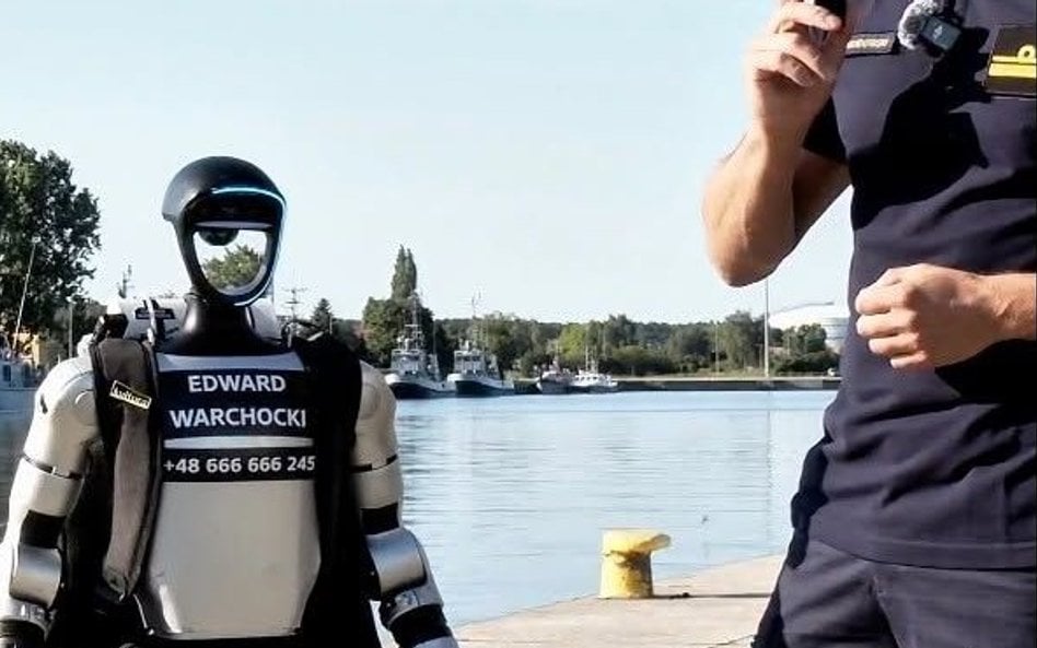 Humanoidalny robot Edward Warchocki na tle polskich okrętów w Świnoujściu.