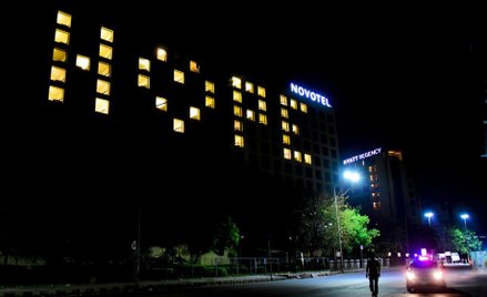 Indie, pokoje hotelowe z włączonymi światłami tworzą słowo „Nadzieja” na fasadzie, podczas dziewięci