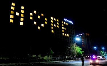 Indie, pokoje hotelowe z włączonymi światłami tworzą słowo „Nadzieja” na fasadzie, podczas dziewięci