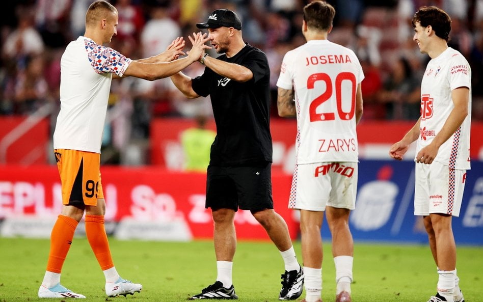 Bramkarz Górnika Zabrze Tomasz Loska (L) i właściciel klubu Lukas Podolski (2L) cieszą się ze zwycię