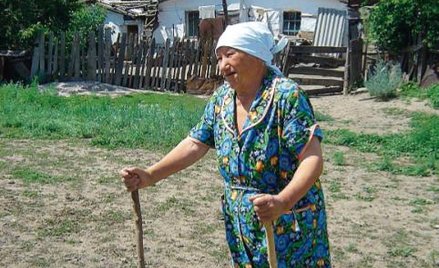 Polka z Oziorska na tle swojej „chaty stalinowskiej” z 1936 r.
