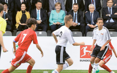 Piłka nożna to oczko w głowie Xi Jinpinga. Na zdjęciu z Angelą Merkel obserwuje zmagania juniorów