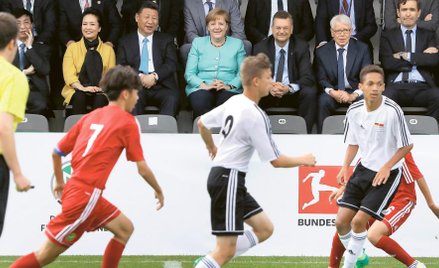 Piłka nożna to oczko w głowie Xi Jinpinga. Na zdjęciu z Angelą Merkel obserwuje zmagania juniorów