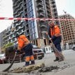 Pracownicy komunalni sprzątają teren w miejscu ataku rosyjskiego drona w trakcie rosyjskiego ataku n