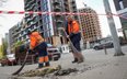 Pracownicy komunalni sprzątają teren w miejscu ataku rosyjskiego drona w trakcie rosyjskiego ataku n