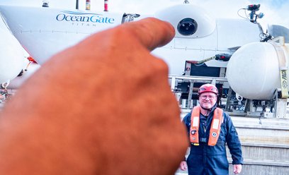 Arthur Loibl, były pasażer Titana, na tle miniaturowej łodzi podwodnej należącej do firmy OceanGate 
