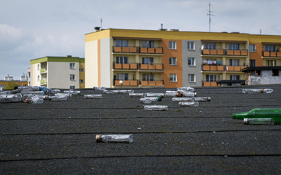 Butelki po alkoholu leżące na dachu zabudowań gospodarczych na jednym z osiedli