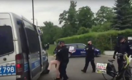 Policja zatrzymuje rowerzystkę. Na rowerze napisy "Wolna Trójka" i "Pisiory mordują utwory"
