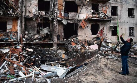 Mężczyzna przed blokiem na przedmieściach Kijowa zniszczonym przez Rosjan, 25 lutego 2022 r.