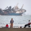 Ludzie gromadzą się na plaży, w pobliżu plaży Bandar Abbas widać statek na Cieśninie Ormuz