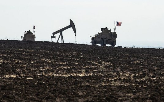Żołnierze amerykańscy mijający żuraw pompowy na polu roponośnym w pobliżu miejscowości Ain Diwar na 
