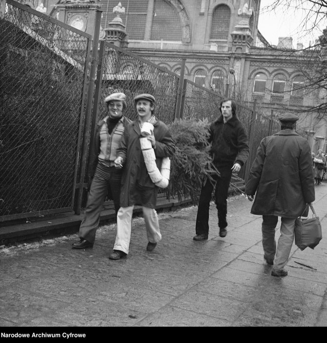 Plac Mirowski. Mężczyźni wracających z zakupów. W tle budynek Hali Mirowskiej