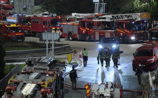 Hongkong. Ratownicy w trakcie akcji w kompleksie Wang Fuk Court