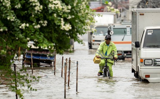 Rowerzysta przedziera się przez zalane drogi w Apalit w prowincji Pampanga na Filipinach