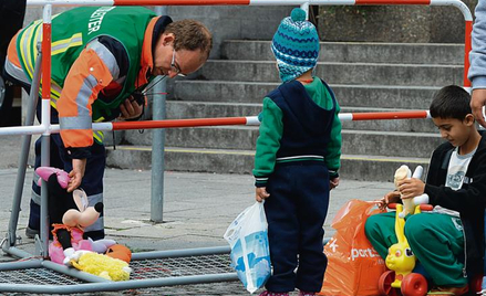 Niemiecki ochotnik przygotowuje zabawki na przyjazd uchodźców. Monachium, lato 2015 r.
