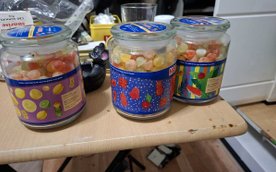 W komodzie oraz przy oknie znajdowały się szklane słoiki i plastikowe pudełka wypełnione kolorowymi 